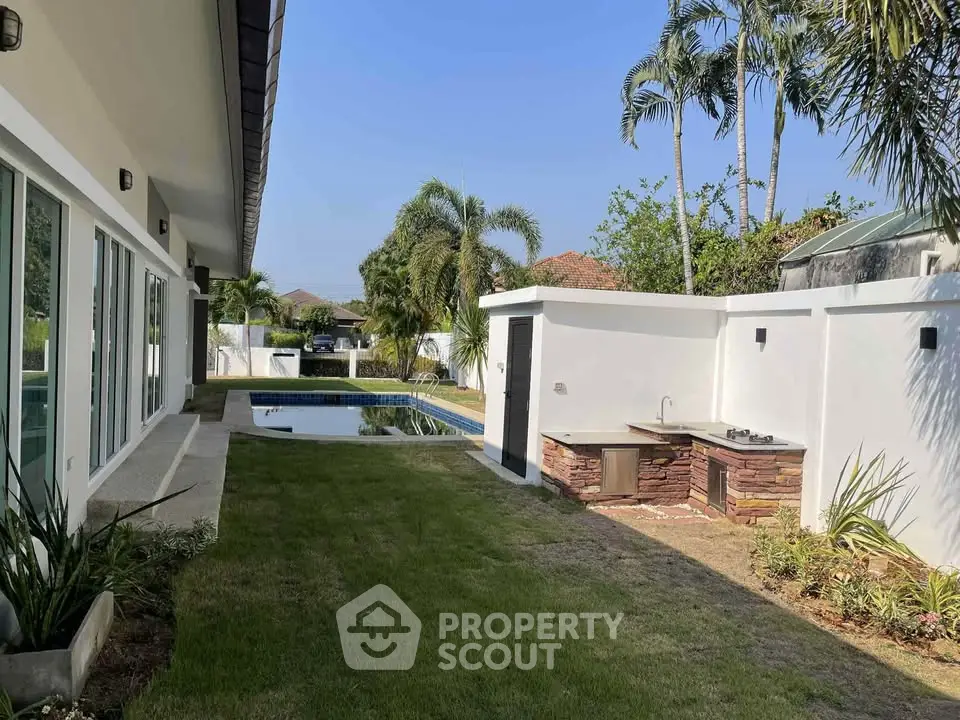 Luxurious backyard with pool and outdoor kitchen in tropical setting