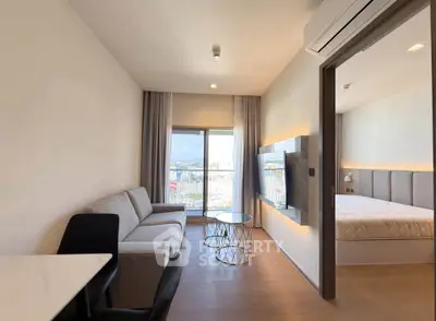 Modern apartment with open living room and bedroom, featuring stylish furniture and a scenic balcony view.