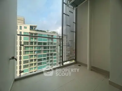 Spacious balcony with modern railing and city view in high-rise apartment.