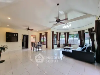 Spacious open living room with modern decor and large windows for natural light.
