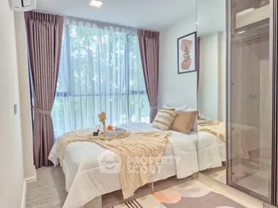 Modern bedroom with large window, elegant decor, and mirrored wardrobe in a stylish apartment.