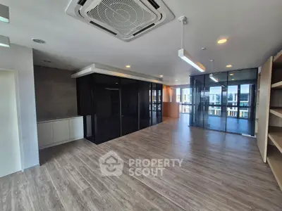 Spacious modern living room with glass partitions and wooden flooring