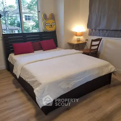 Cozy bedroom with wooden flooring and stylish decor in a modern home.