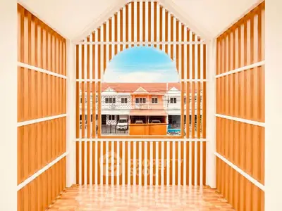 Charming balcony with wooden slats offering a picturesque view of neighboring houses.
