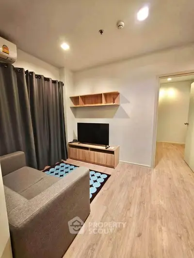 Modern living room with cozy sofa, stylish TV stand, and elegant wooden flooring.