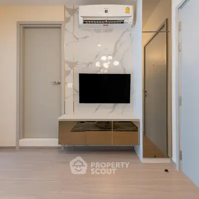 Modern living room with sleek TV setup and air conditioning unit.