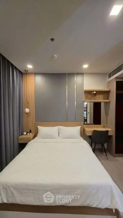Modern bedroom with sleek design, featuring a comfortable bed and stylish workspace.