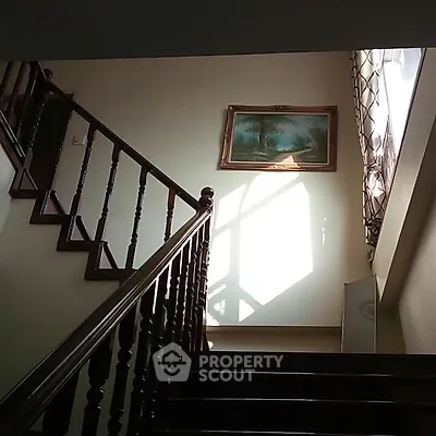 Elegant staircase with wooden railing and natural light in a cozy home