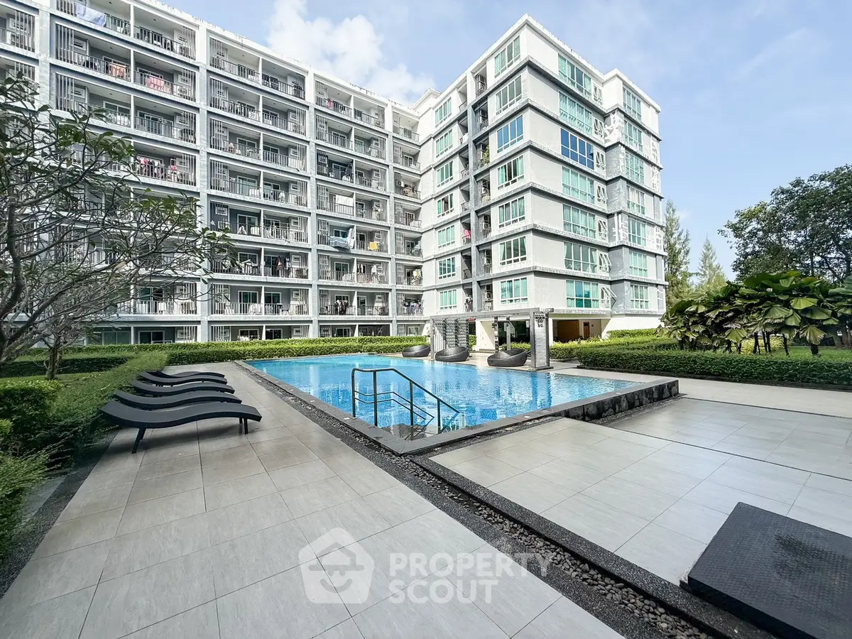 Modern apartment complex with pool and lush greenery