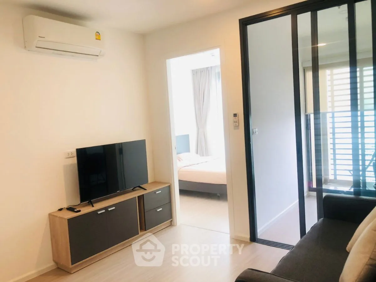 Modern living room with TV and air conditioning, adjacent to a cozy bedroom.