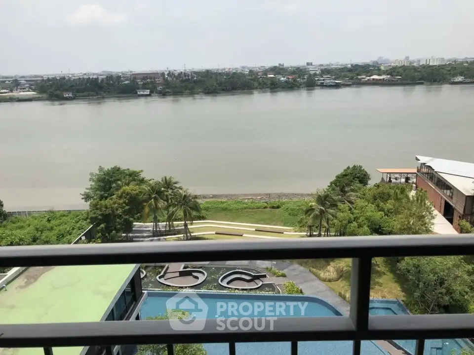Stunning river view from high-rise balcony with lush greenery and pool below.