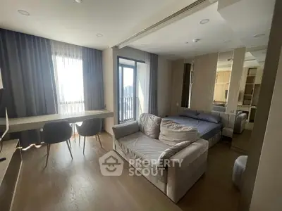 Modern living room with cozy seating and large windows offering city views.