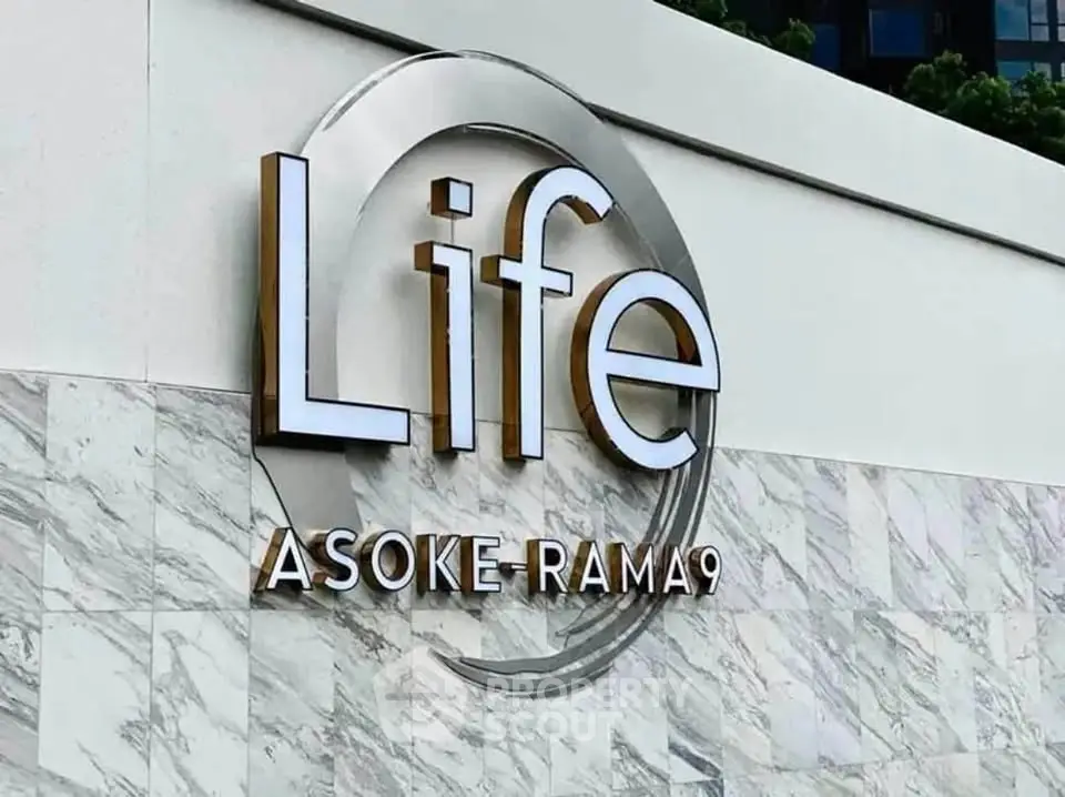 Modern building exterior with stylish Life Asoke-Rama 9 signage, showcasing luxury urban living.