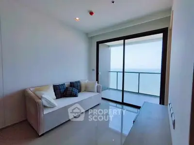 Modern living room with ocean view balcony and sleek furnishings.