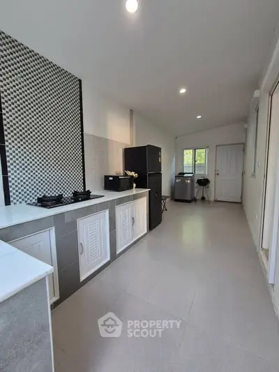 Modern kitchen with sleek design, featuring gas stove and ample storage space.