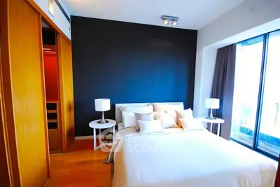 Modern bedroom with large window and stylish decor in a luxury apartment.