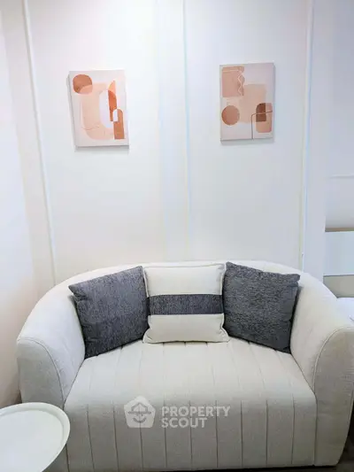 Cozy living room with modern art and plush sofa, perfect for relaxation.