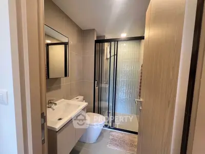 Modern bathroom with sleek design, featuring a glass shower enclosure and stylish vanity.