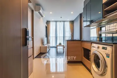 Modern apartment interior with open kitchen and washing machine, featuring sleek design and ample natural light.