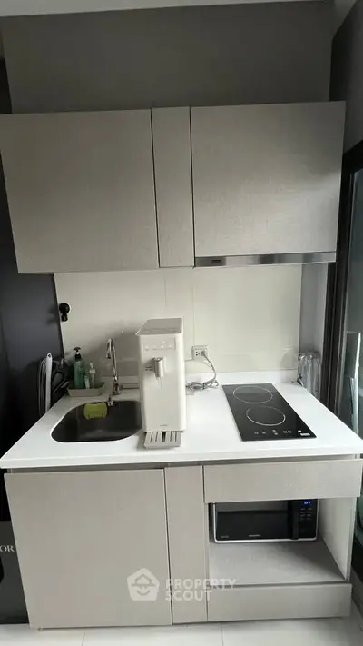 Modern compact kitchen with sleek cabinetry and built-in appliances, perfect for urban living.