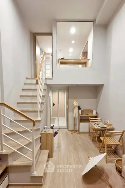 Modern duplex interior with stylish staircase and cozy dining area, perfect for urban living.