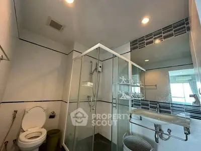 Modern bathroom with glass shower and sleek fixtures in contemporary home.