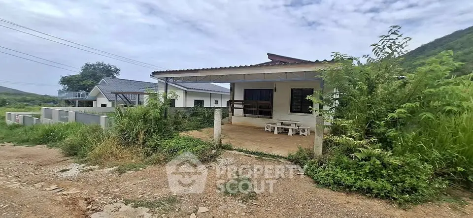 Charming countryside house with spacious patio and lush greenery, perfect for serene living.
