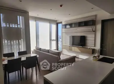 Modern living room with sleek furniture and large windows offering city views.