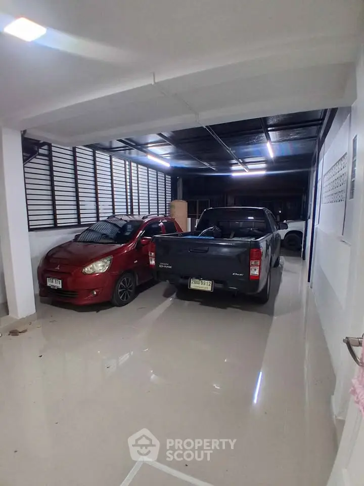Spacious indoor parking area with two cars in a modern residential building.