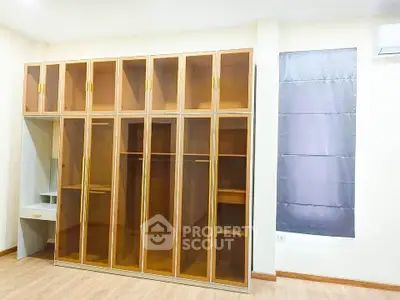 Spacious bedroom with elegant built-in wardrobes and modern window treatment.