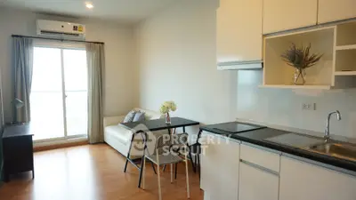 Modern apartment interior with open kitchen and cozy living area, featuring natural light and stylish decor.