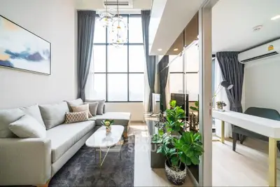 Modern living room with large windows and stylish decor in a high-rise apartment.