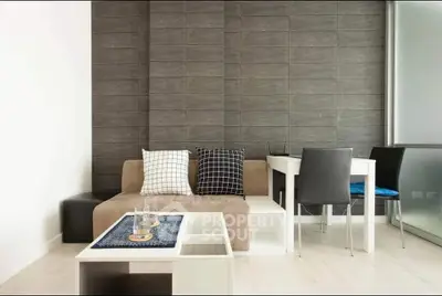 Modern living room with stylish decor and dining area, featuring a cozy sofa and sleek table.