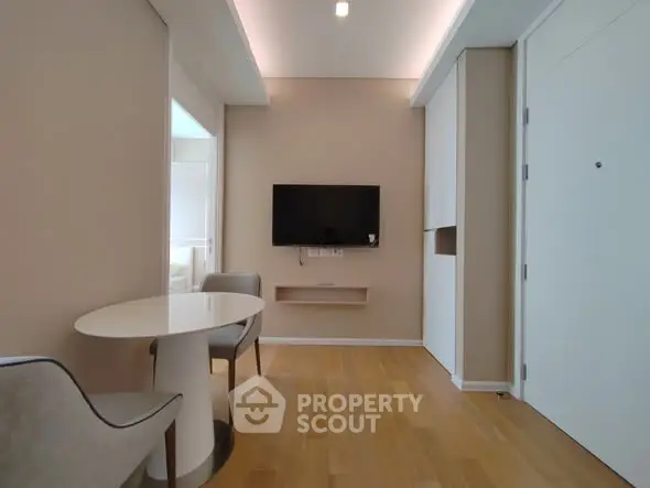 Modern minimalist living room with wall-mounted TV and elegant seating area.