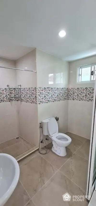 Modern bathroom with floral tile accents and glass shower enclosure