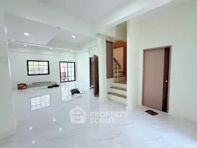 Spacious modern living room with glossy marble floors and staircase