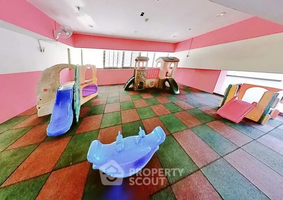 Vibrant indoor play area with colorful slides and soft flooring in a residential building.