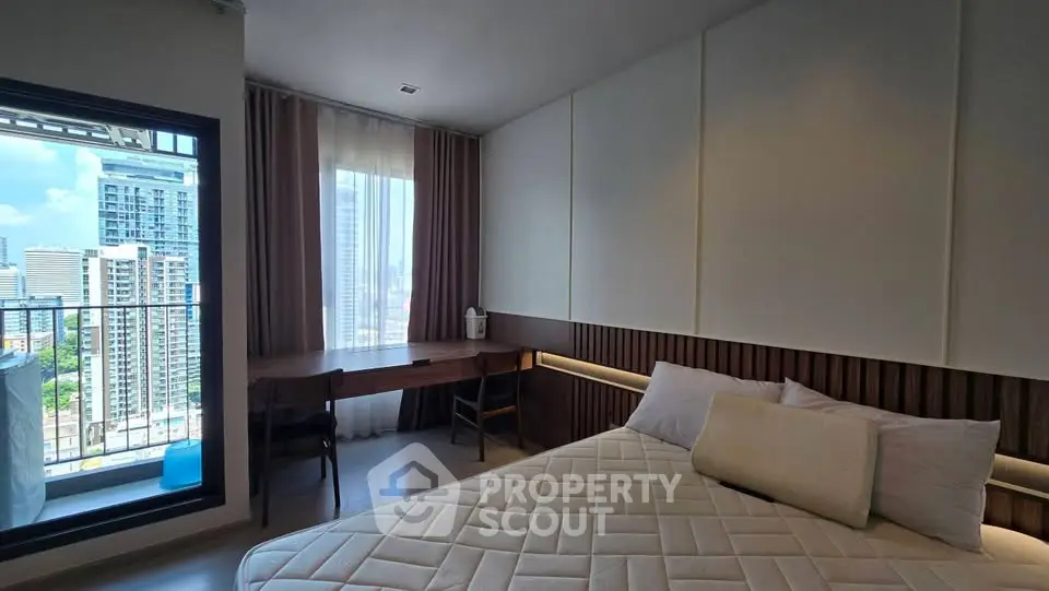 Modern bedroom with city view and balcony access in high-rise apartment