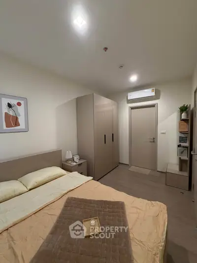 Cozy bedroom with modern decor and ample storage space, featuring a comfortable bed and stylish artwork.