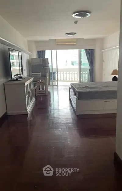 Spacious studio apartment with balcony and modern furnishings, perfect for urban living.