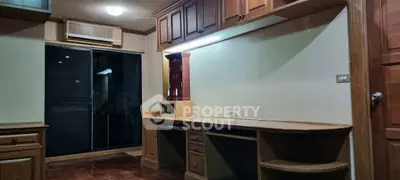 Spacious study room with built-in wooden desk and cabinets, ideal for home office setup.