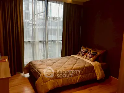 Cozy bedroom with elegant decor and large window for natural light.