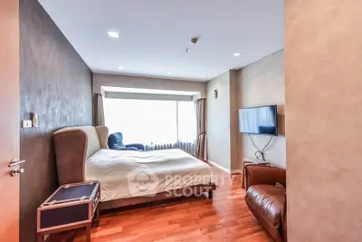 Spacious bedroom with modern decor and large window for natural light