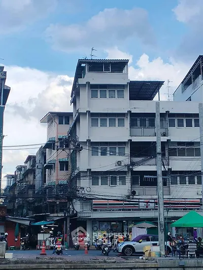 Urban street view with multi-story building and bustling market scene