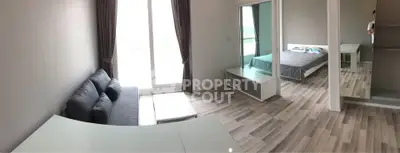 Modern living room with large window and adjacent bedroom, featuring sleek furniture and stylish flooring.