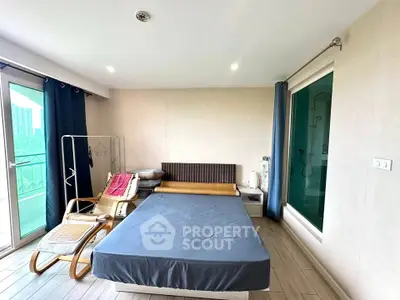 Spacious bedroom with modern decor and large windows offering natural light.