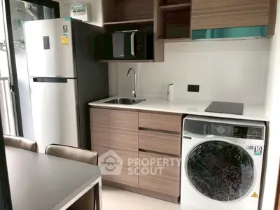Modern compact kitchen with washing machine and sleek appliances in urban apartment