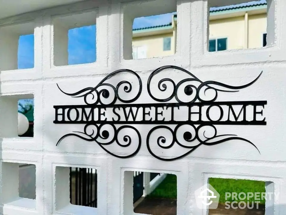 Charming exterior wall with decorative 'Home Sweet Home' sign, perfect for welcoming ambiance.