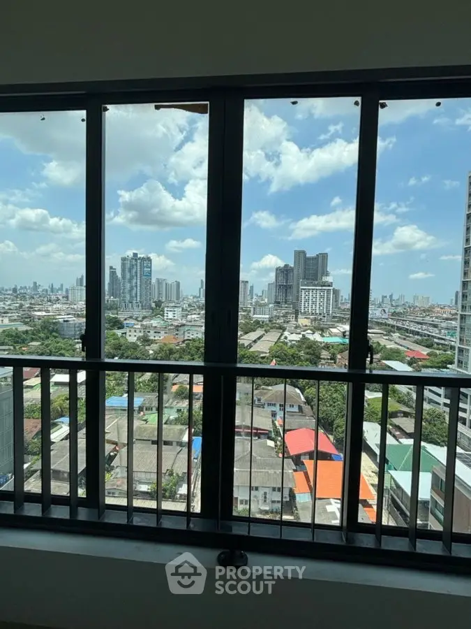 Stunning cityscape view from a high-rise balcony with expansive skyline and blue skies.