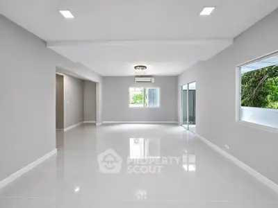 Spacious modern living room with glossy tile flooring and large windows for natural light.